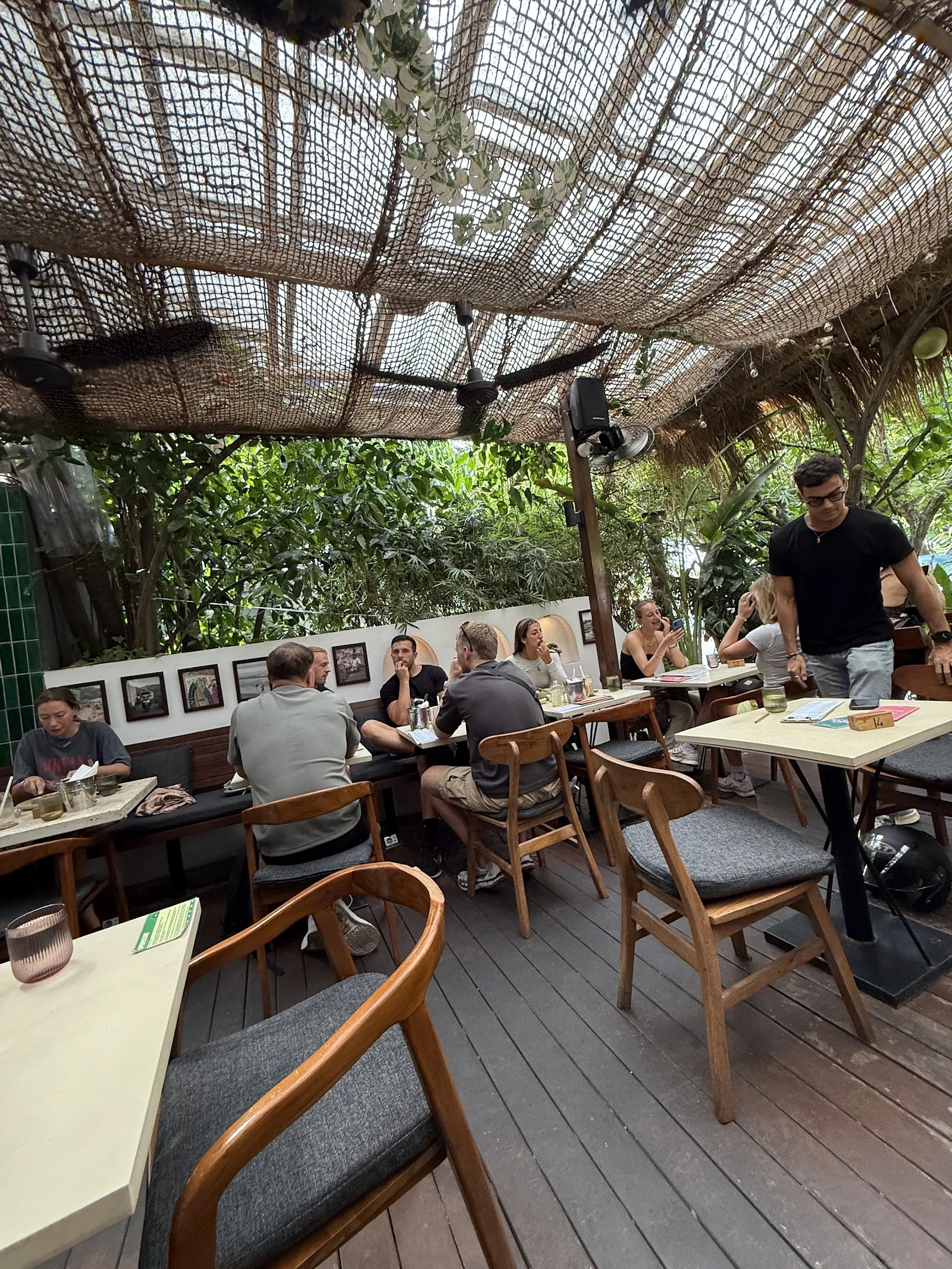Sous le toit de rotin, banquettes et tables en teck.
